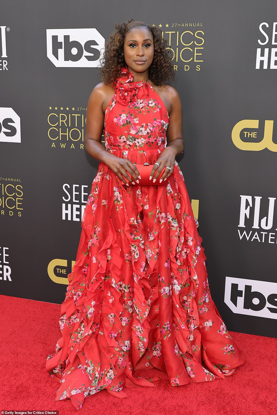 Spring is ready: Issa Rae looked beautiful in a bright red floral dress with floral motifs along the halter neckline.