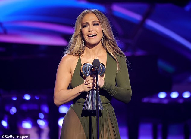 Onstage: They all looked on as 52-year-old Lopez took to the stage to receive the award in a stunning olive green dress with a plunging neckline.