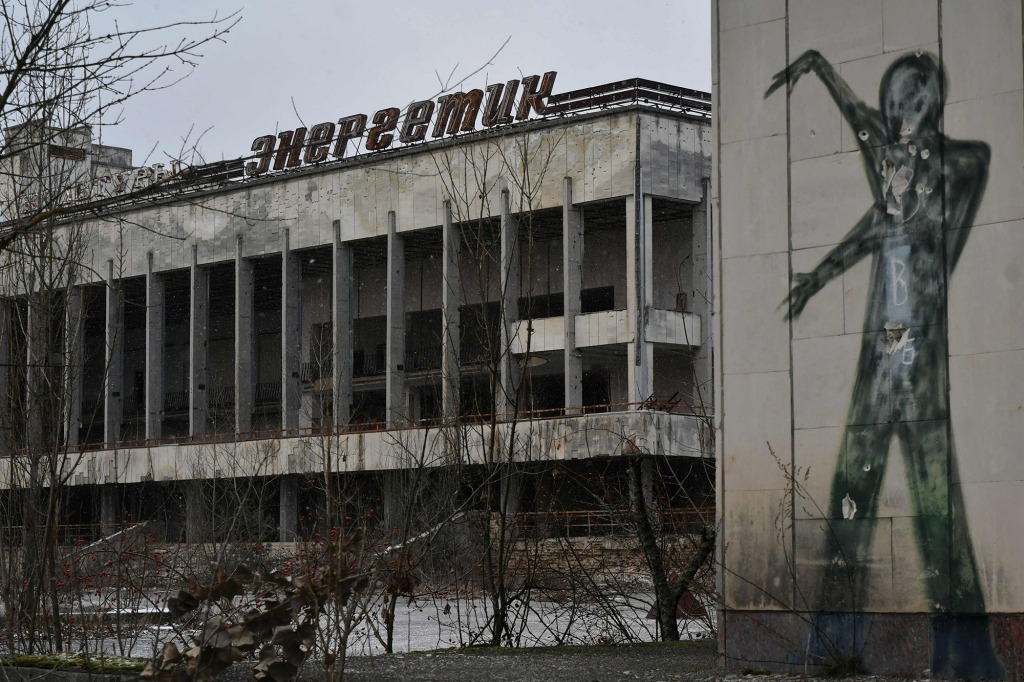 A file photo taken on December 8, 2020 shows graffiti on the wall of a building in the central square of the ghost town of Pripyat, close to the Chernobyl nuclear power plant.