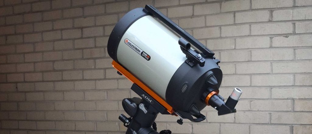 A Celestron advanced vx 8-inch edge hd telescope in front of a brick wall