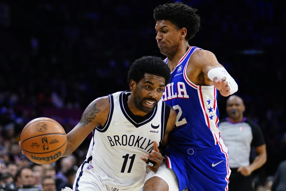 Keri Irving of the Brooklyn Nets, left, passes Mathis Thieppole of the Philadelphia 76ers during the second half of an NBA basketball game, Thursday, March 10, 2022, in Philadelphia.  (AP Photo/Matt Slocum)