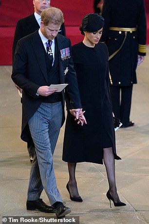 Prince Harry and Meghan, Duchess of Sussex, attend the coffin procession of Queen Elizabeth II from Buckingham Palace to Westminster Hall